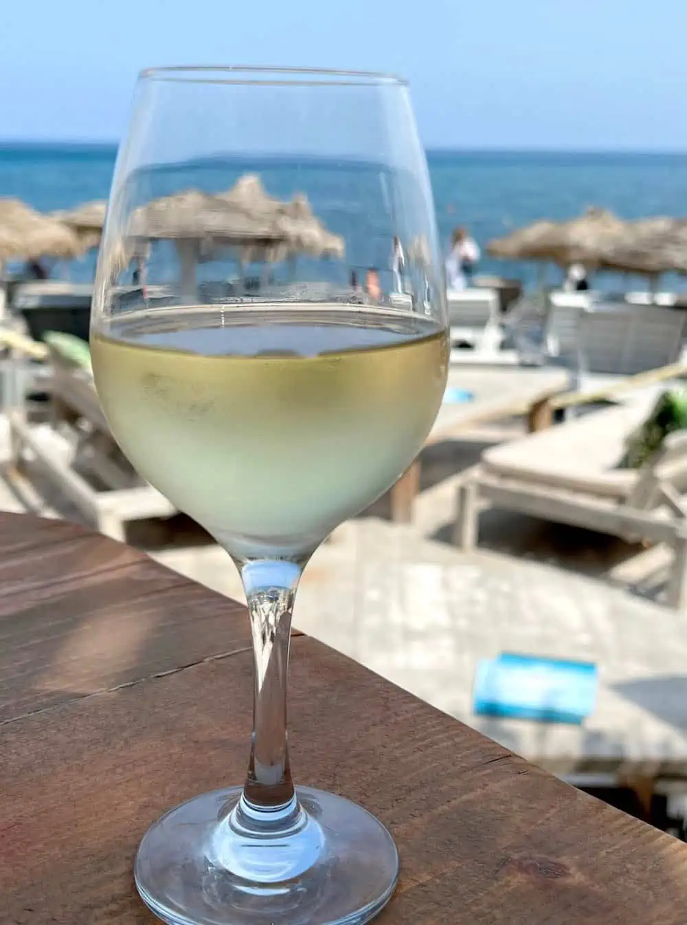 A glass of white wine at a beac in Santorini.