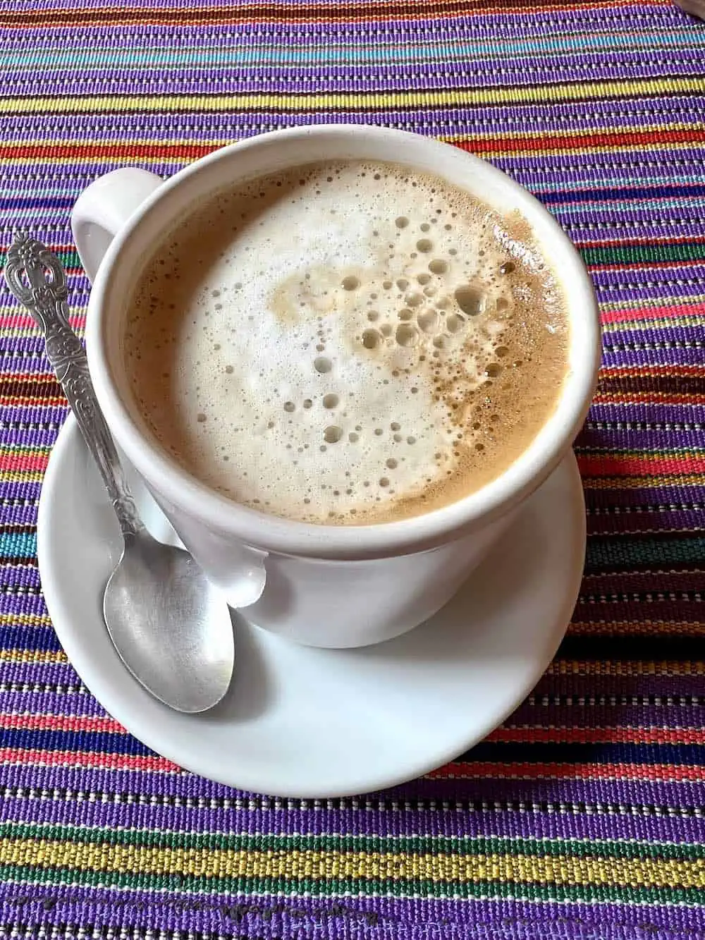 A mug of Guatemalan coffee on a woven tablecloth. 