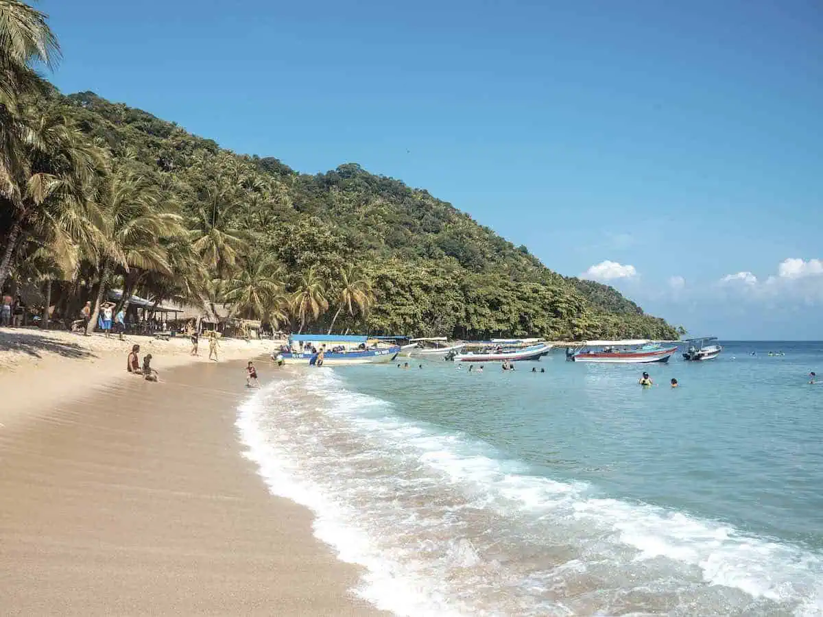 A beach in Honduras with peoplel swimming. 