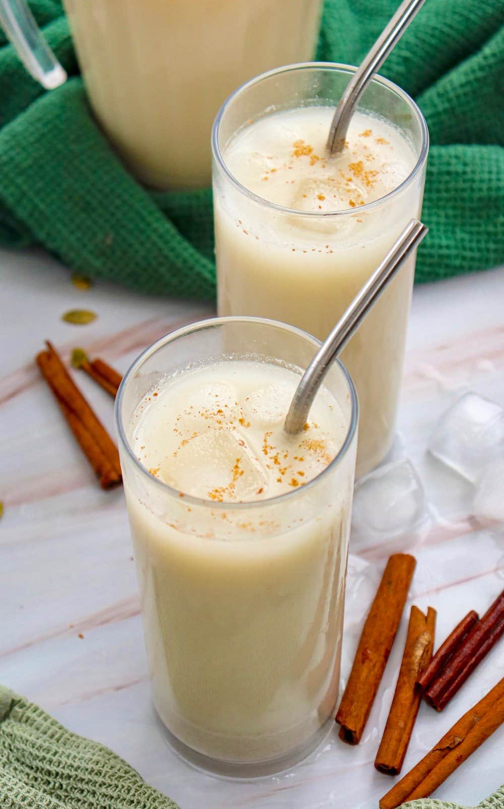 Two glasses of Guatemalan agua de horchata (rice drink) with cinnamon sticks.