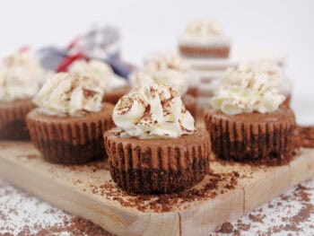 Collection of mini chocolate Kahlua cheesecakes on a wooden board.