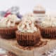 Collection of mini chocolate Kahlua cheesecakes on a wooden board.