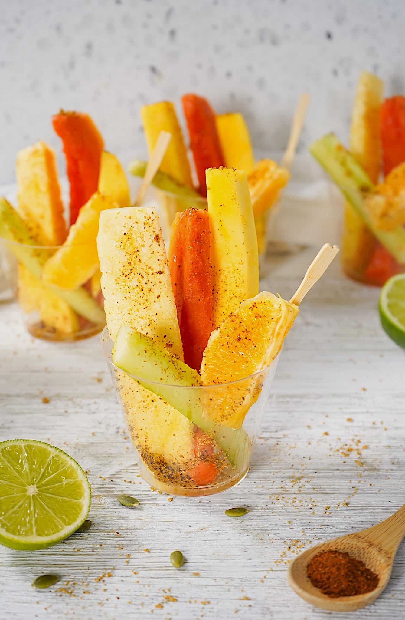 Fruit cups sprinkled with spiced ground pumpkin seeds on a table. 
